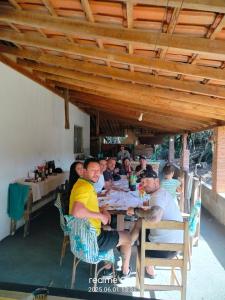 a group of people sitting at a table in a restaurant at Paraíso dás águas in Botelhos