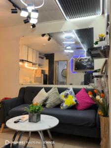 a living room with a blue couch with colorful pillows at Entire 2BR condo Centro Spatial Downtown in Davao City