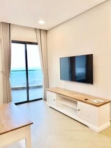 a living room with a flat screen tv on a wall at Căn hộ du lịch 2 phòng ngủ Aria Vũng Tàu Hotel & Villa Resort, Hồ bơi và bãi tắm riêng miễn phí, 30m ra biển in Vung Tau