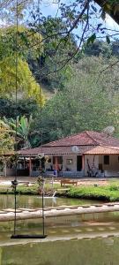 a building next to a body of water at Paraíso dás águas in Botelhos