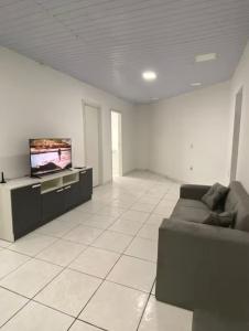a living room with a couch and a flat screen tv at Apartamento grande para família ou amigos in Boa Vista