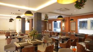 a restaurant with tables and chairs in a room at Elysiumarc Hotel & Resort 