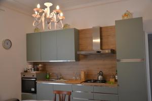 a kitchen with white cabinets and a stove at Casa Mila in Marina di Carrara