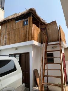 a small house with a staircase leading up to it at Maison calme et fleurie in Cotonou