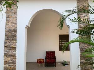 an archway with two chairs in a room at Maison calme et fleurie in Cotonou +32 photos