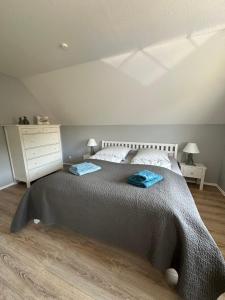 Un dormitorio con una cama con dos toallas azules encima. en Born 1A, en Born