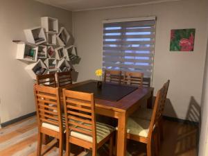 Un comedor con mesa y sillas de madera. en Rent House 1745, en Osorno