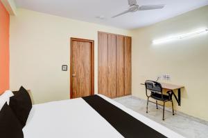 a bedroom with a bed and a desk with a chair at Hotel O Balaji Palace in Noida +19 photos
