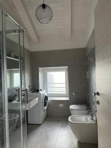 a bathroom with a washing machine and a sink at Casa Marina in Villammare