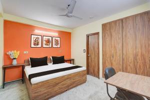 a bedroom with a bed and an orange wall at Hotel O Balaji Palace in Noida