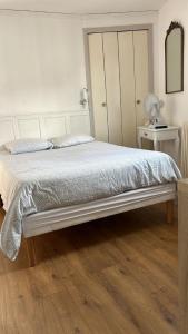 Schlafzimmer mit einem großen weißen Bett und einem Spiegel in der Unterkunft Bristol Manor N20 terrasse cuisine et chambre in Néris-les-Bains