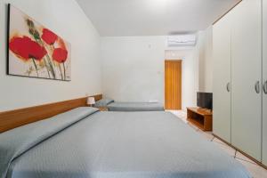 a bedroom with a large bed and a television at Green Village Accommodations in Colico
