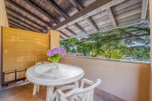 a table with a vase of flowers on a balcony at Green Village Accommodations in Colico