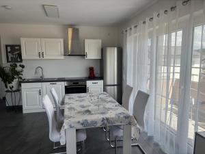 a kitchen with a table with white chairs and a sink at Auszeit in Volkertshausen +7 photos