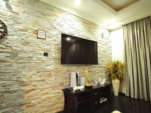 Habitación con pared de piedra y TV. en Villa Soteria, en Abuja 10 fotos más