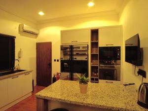Una cocina con gabinetes blancos y encimera. en Villa Soteria, en Abuja