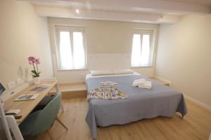 a small room with a bed and a desk and a desk at Photomusic Boutique Rooms in Senigallia