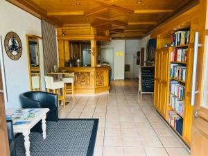 eine Bibliothek mit einem Tisch, Stühlen und Bücherregalen in der Unterkunft Landhaus Magnus in Ramberg
