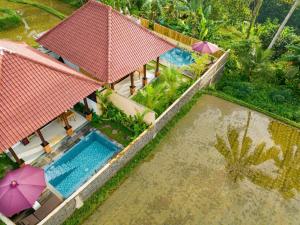an aerial view of a house with a swimming pool at Dukuh Sari Villa in Ubud +6 photos