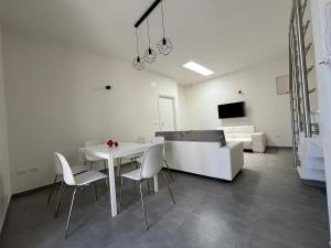 un soggiorno con tavolo, sedie e divano di La casetta della piazza a Carovigno