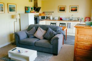 a living room with a couch and a kitchen at The Studio in Georgeham +9 photos