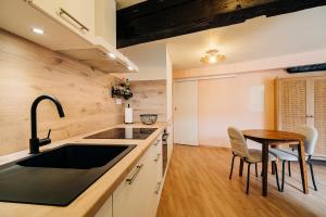a kitchen with a sink and a wooden table at Suite Vieille Ville - Calme et Cosy - Parking gratuit in Sélestat