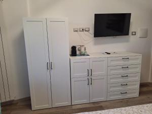 a white cabinet with a television on a wall at La Risacca in Pietra Ligure