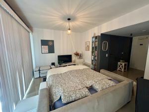 a bedroom with a large bed and a couch at Studio Zilte Rust - Zeedijk Middelkerke in Mellet