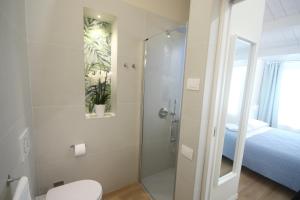 a bathroom with a shower and a toilet and a bed at Photomusic Boutique Rooms in Senigallia +33 photos