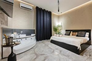 a bedroom with a tub and a bed and a sink at Falco Boutique Home - Jacuzzi In Camera in Naples