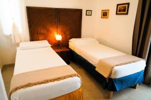 オストゥーニにあるLa Terrazza sugli Ulivi - con PISCINA PANORAMICAのベッド2台とランプが備わったホテルの部屋