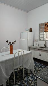 a kitchen with a table with chairs and a refrigerator at Paraíso dás águas in Botelhos