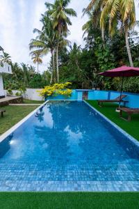 a swimming pool in a resort with palm trees at Heaven Breeze Hotel Ahangama in Ahangama