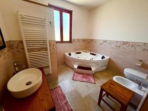 a bathroom with a tub and a toilet and a sink at I Tre Pozzi in Faccia di Trippa