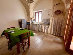 a kitchen with a table with a green table cloth at I Tre Pozzi in Faccia di Trippa