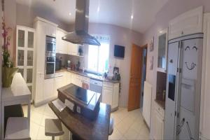 a kitchen with white cabinets and a black counter top at Suite 2Chambres salle de bain privés toilettes Terrasse Parking 30 min de Paris in Corbeil-Essonnes