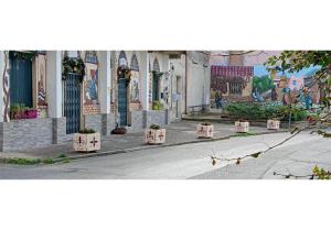 a street with plants in pots on the side of a building at Eremo degli Artisti in Ussana