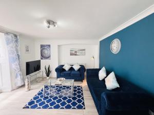 a living room with blue walls and a blue couch at The Barbican Apartments in Plymouth