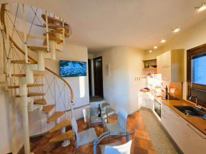 a kitchen with a spiral staircase in a room at Dimora degli ulivi in Badesi