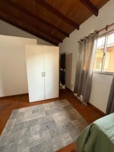 a bedroom with white cabinets and a large window at Depto alquiler por día in Apóstoles