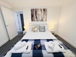 a bedroom with a bed with two white towels at The Barbican Apartments in Plymouth +9 photos