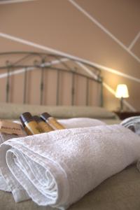 a pile of towels sitting on top of a bed at Albergo diffuso Borgo Gallodoro da Sara in Gallodoro