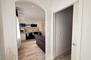 a living room with a couch and a kitchen at Le St Roch - Cosy & Confort in Roanne
