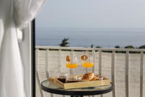 einen Tisch mit Gläsern Orangensaft und Brot auf dem Balkon in der Unterkunft Studio Andrea in Dubrovnik