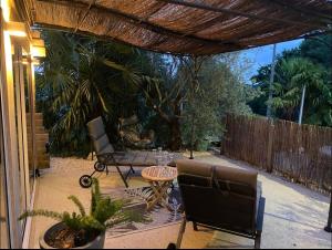 a patio with two chairs and a table and a fence at Chambre élégante avec terrasse in Souvigny