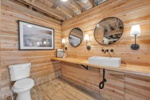 a bathroom with wooden walls and a white toilet and a sink at The Morgan in Gulf Shores +26 photos
