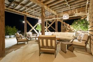a patio with white furniture and tables and chairs at The Morgan in Gulf Shores
