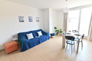 un salon avec un canapé bleu et une table dans l'établissement IzzHome Oasis, à Pula