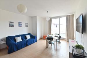 un salon avec un canapé bleu et une table dans l'établissement IzzHome Oasis, à Pula