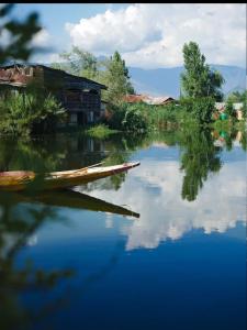 a house and a boat on a body of water at Houseboat young Minar in Srinagar +29 photos